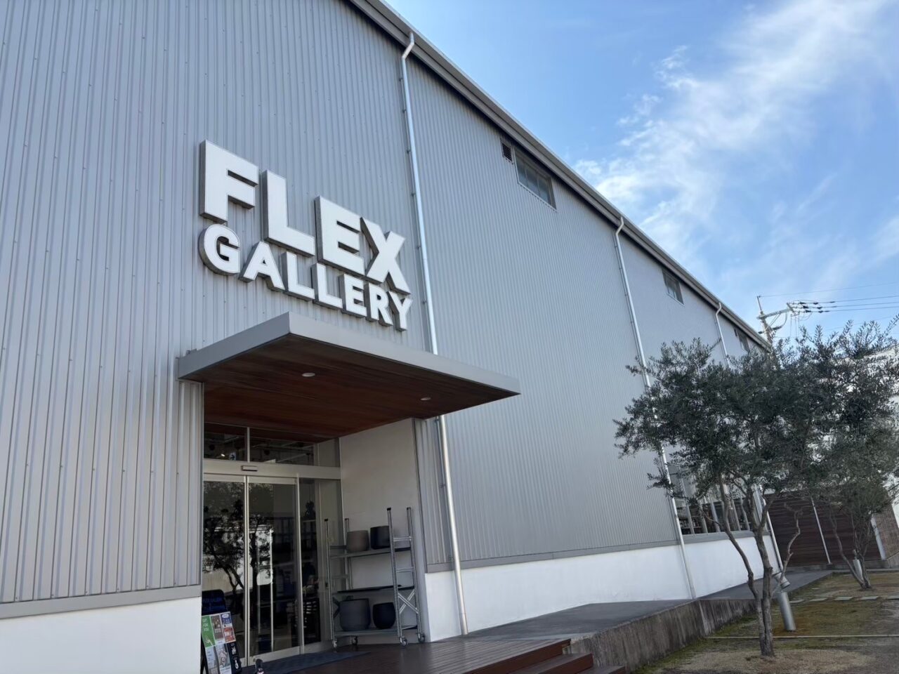 FLEXGALLERYの店舗外観。スタイリッシュなデザインの建物。