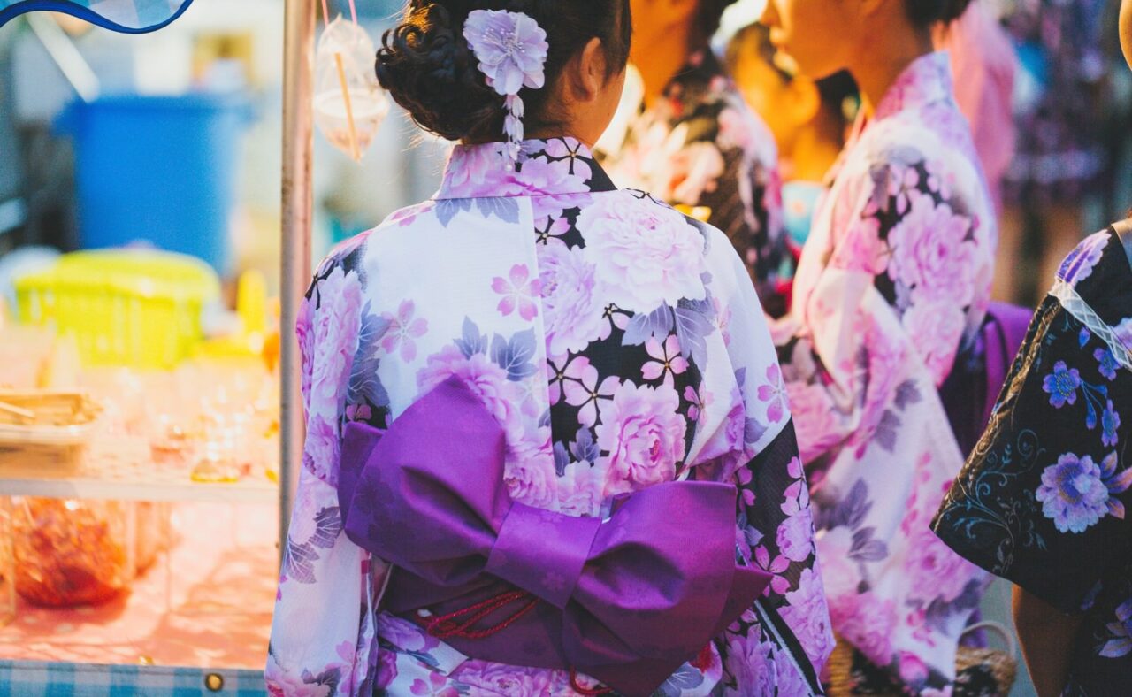 夕暮れの中、灯りがともる空鞘稲生神社の屋台。夏祭りらしい懐かしい雰囲気が広がる。