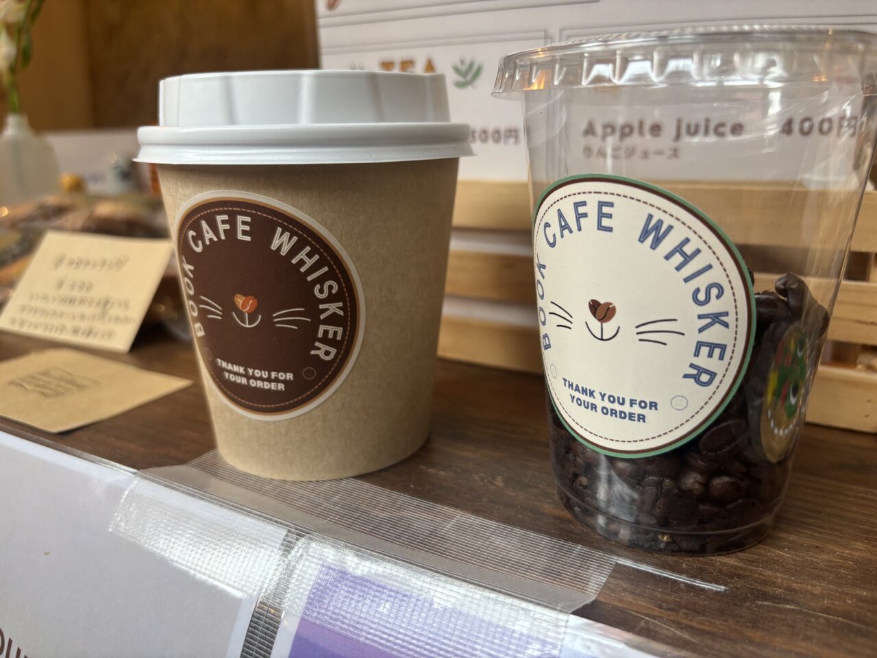 猫のヒゲのマークがデザインされたブックカフェ ウィスカーのドリンクカップ。店名の由来を感じさせる可愛らしいデザイン