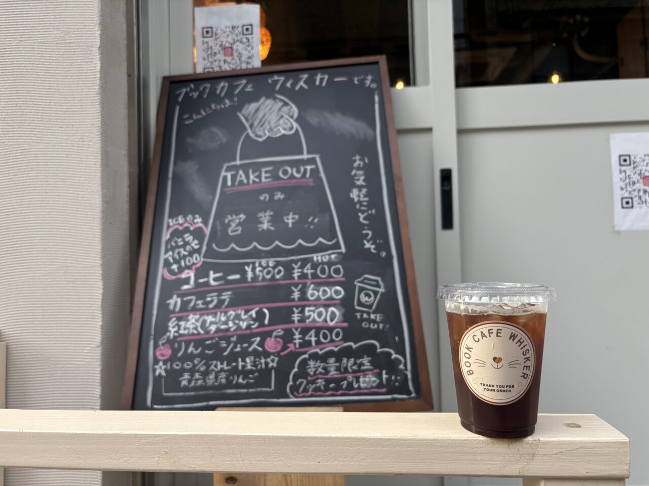 ブックカフェ ウィスカーの外観に掲げられた看板。店名が書かれたシンプルなデザイン