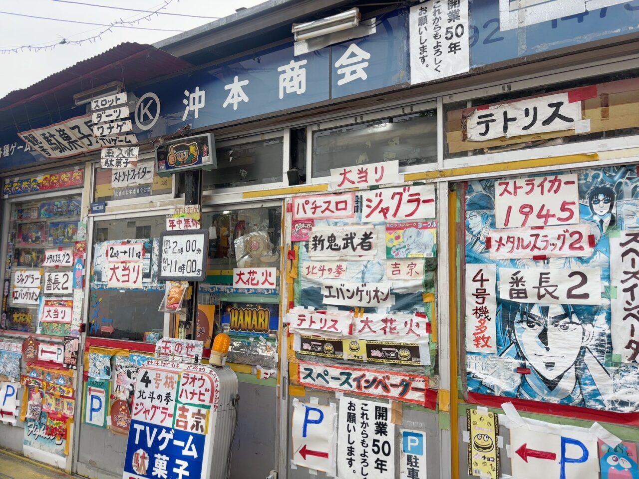 沖本商会のレトロな外観。昭和風ポスターが貼られた店舗正面。