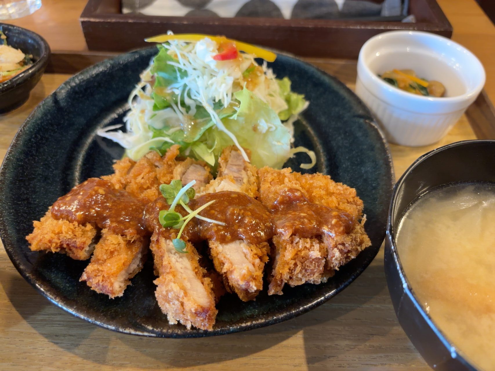 サクサクに揚がった豚カツ定食。小鉢とお味噌汁付き。
