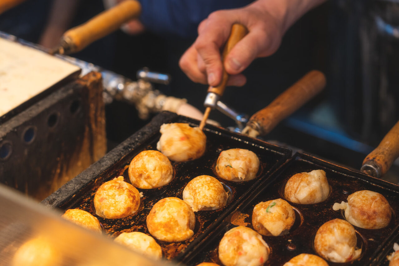 アツアツで香ばしいたこ焼きが並ぶ屋台のイメージ