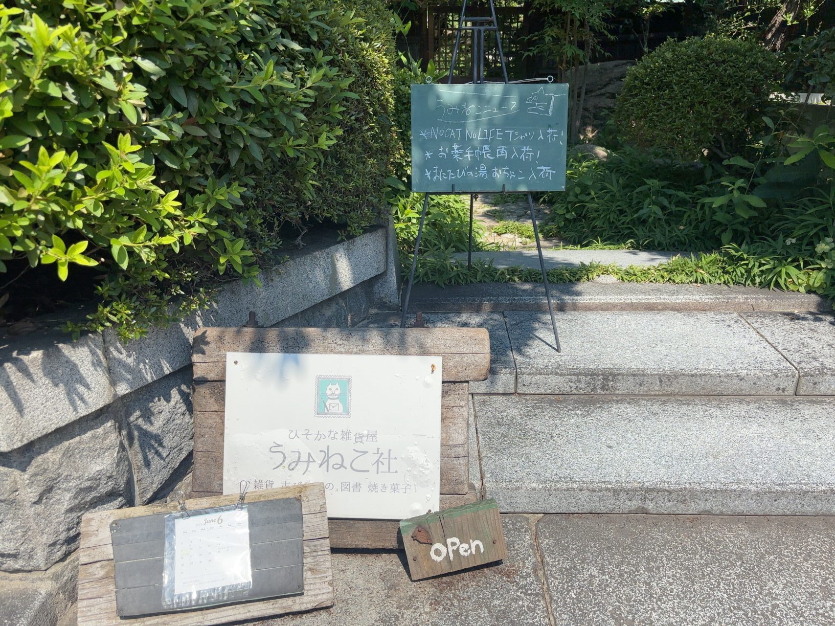  店先に置かれた「うみねこ社」の木製看板