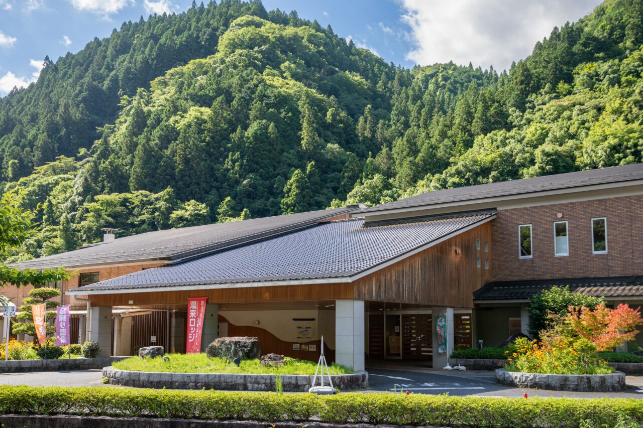 湯来ロッジの外観。緑の木々に囲まれた落ち着いた雰囲気の温泉施設。