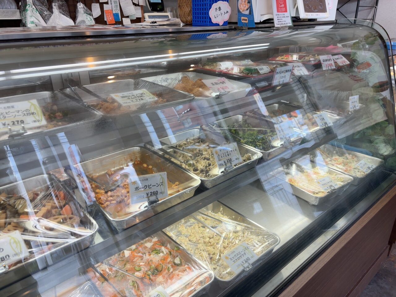 お惣菜が並ぶショーケースの様子。揚げ物や手作り惣菜がずらりと並んでいる