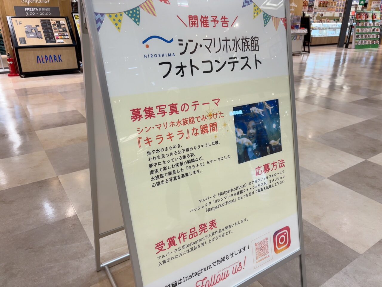 「キラキラな瞬間」をテーマにしたフォトコンテストの案内看板。館内の撮影スポット情報も掲載。