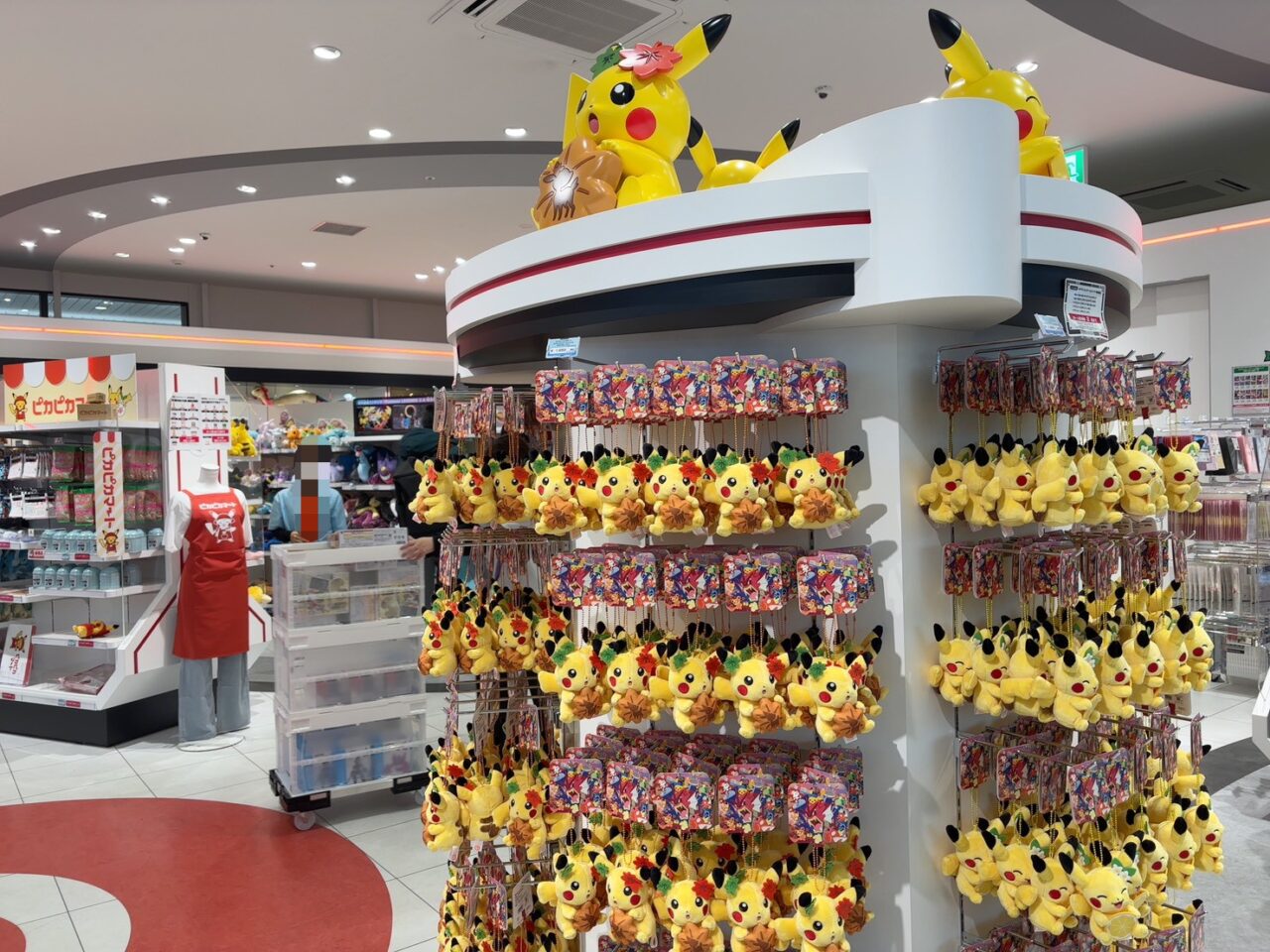 ピカチュウのぬいぐるみやキーホルダーが並ぶ販売コーナー
