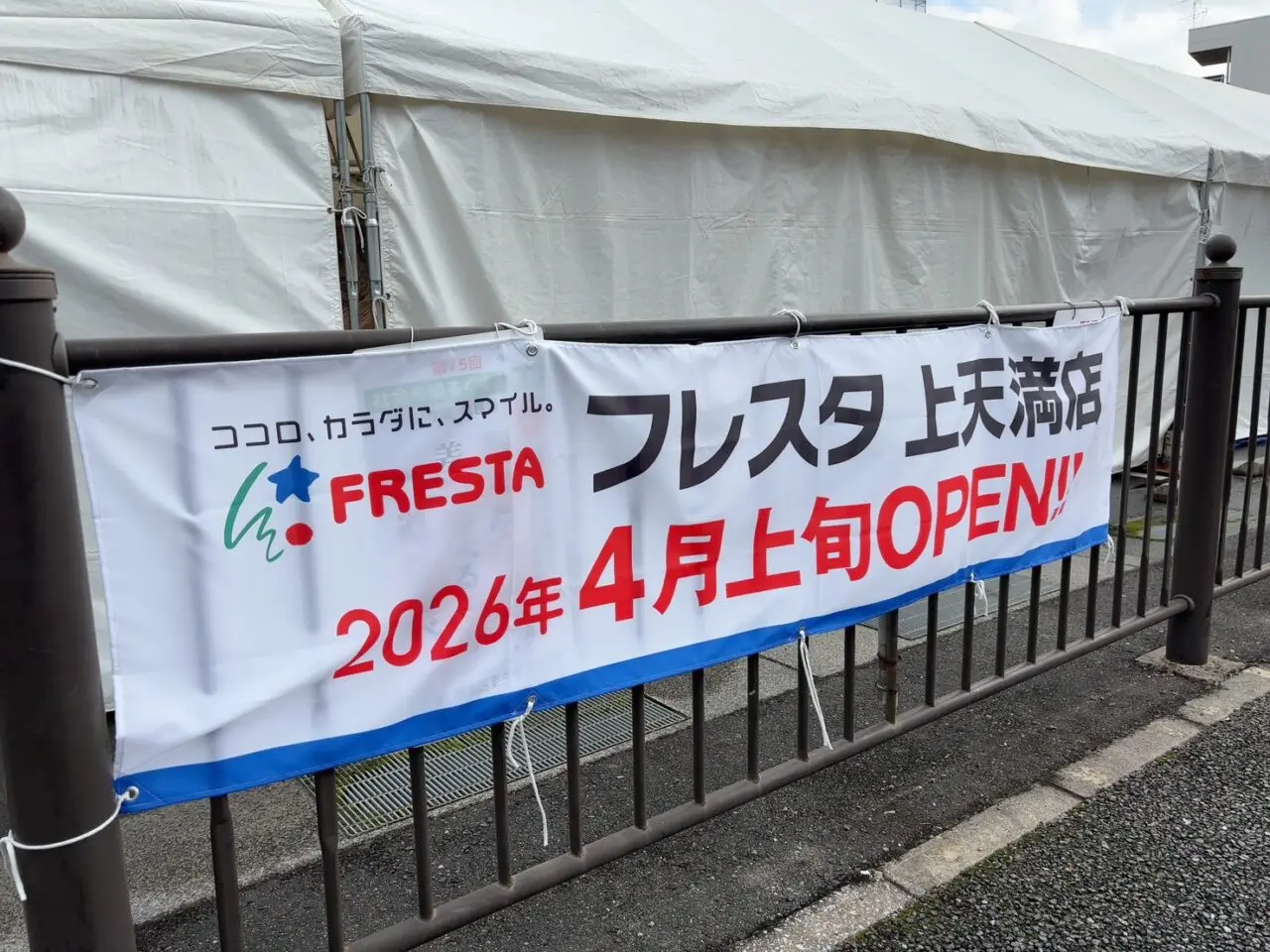 改装工事のため囲いが設置された広島市西区のフレスタ上天満町店外観。2026年4月上旬リニューアルオープンの看板が掲示されている様子