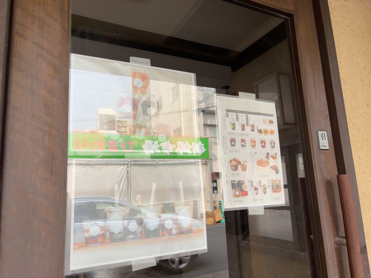 わがしと楽々園店のオープン告知ポスターが掲示された店舗外観