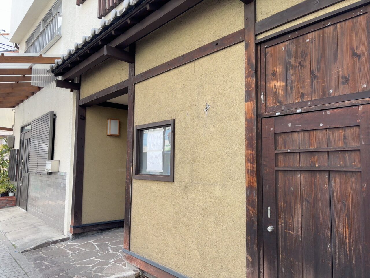 わがしと楽々園店のオープン告知ポスターが掲示された店舗外観