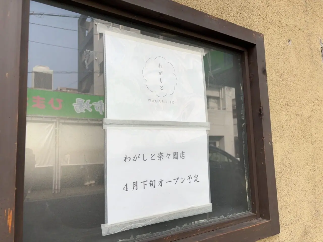わがしと楽々園店のオープン告知ポスターが掲示された店舗外観