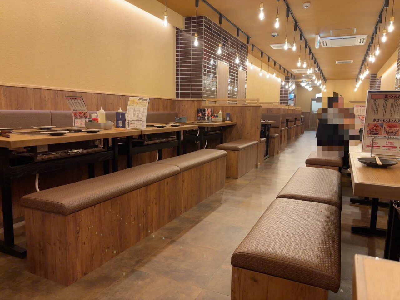 広島市中区本通にオープンした月島もんじゃ たたら 広島本通り店の店内、各テーブルに鉄板が設置されている様子